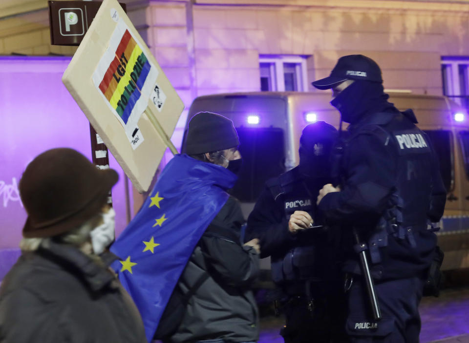 FILE - In this Nov. 5, 2020 file photo, protesters carry an EU flag at an anti-government protest in Warsaw, Poland. Some Poles are afraid that a drawn-out conflict with the EU over the next budget and values could put them on a path toward an eventual departure from the bloc, or "Polexit." Poland's conservative government denies that it has ever wanted to leave the 27-member bloc and popular support for EU membership runs very high. But critics fear the combative tone of some Polish leaders could create momentum which could accidently bring the nation to the exit door.(AP Photo/Czarek Sokolowski, File)