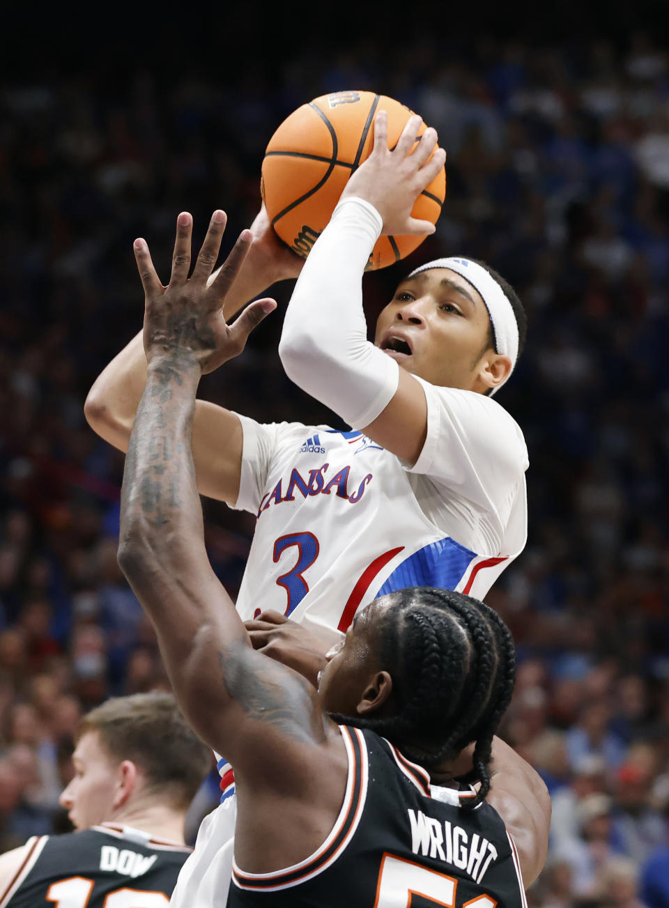 Kansas guard Dajuan Harris Jr. (3) scores against Oklahoma State guard John-Michael Wright (51) during the first half of an NCAA college basketball game, Tuesday, Jan. 30, 2024, in Lawrence, Kan. (AP Photo/Colin E. Braley)