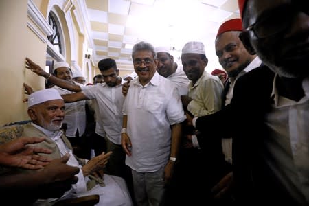 Sri Lanka's former wartime defense secretary and presidential candidate Rajapaksa shares a moment with Muslims during his visit at Ketchimale mosque in Beruwala