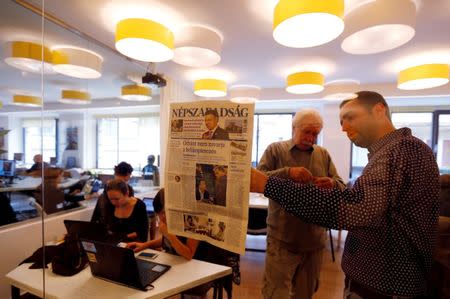 Journalists of the leftist newspaper Nepszabadsag, which was unexpectedly shut down on Saturday amid cries of a crackdown by right-wing Prime Minister Viktor Orban's government, paste a copy of the last issue onto the wall of a temporary newsroom in Budapest, Hungary, October 10, 2016. REUTERS/Laszlo Balogh