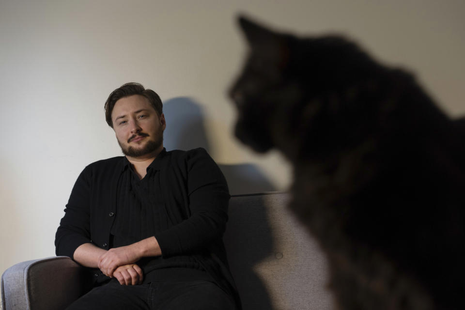 Ashton Colby is photographed with his cat Teddy in his apartment in Columbus, Ohio, on Thursday, Jan. 18, 2024. Ohio Gov. Mike DeWine announced proposals this month that transgender advocates say could block access to gender-affirming care provided by independent clinics and general practitioners, leaving thousands of adults scrambling for treatment and facing health risks. Colby, 31, fears the clinic where he gets the testosterone he has taken since age 19 would no longer offer it. (AP Photo/Carolyn Kaster)