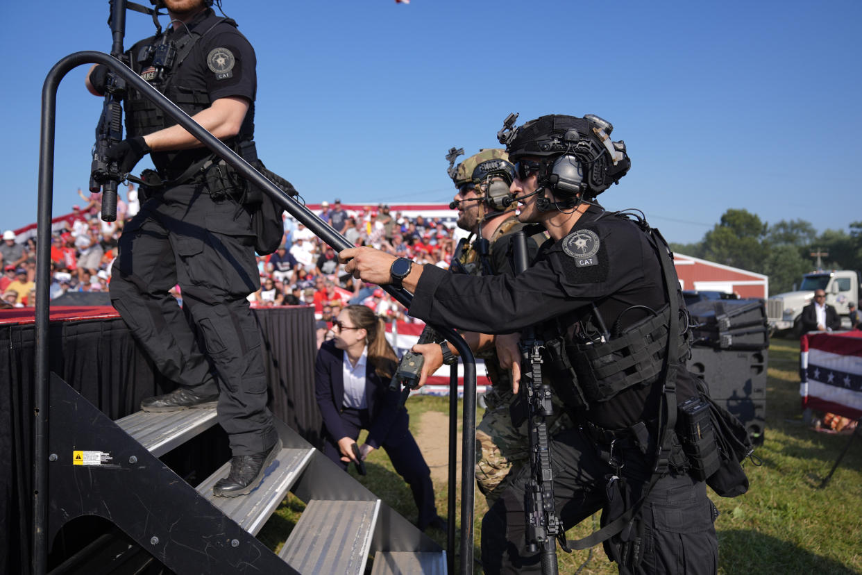 Secret Service agents rush to the stage after the former president was shot at in Butler, Pa. 