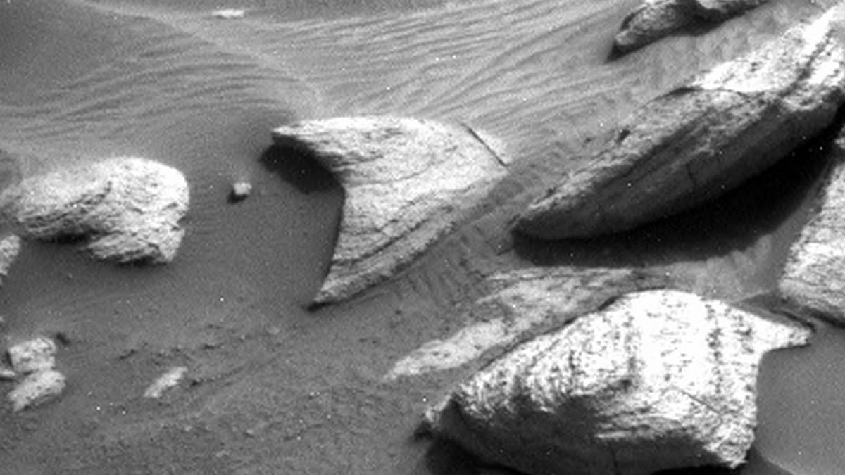  Black and white image of rocks with a delta-shaped rock in the middle. 