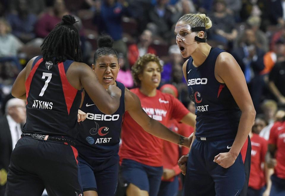 Washington Mystics' Elena Delle Donne, right, celebrates a play with Ariel Atkins, left, and Natasha Cloud, center, during the second half in Game 4 of basketball's WNBA Finals against the Connecticut Sun, Tuesday, Oct. 8, 2019, in Uncasville, Conn. (AP Photo/Jessica Hill)