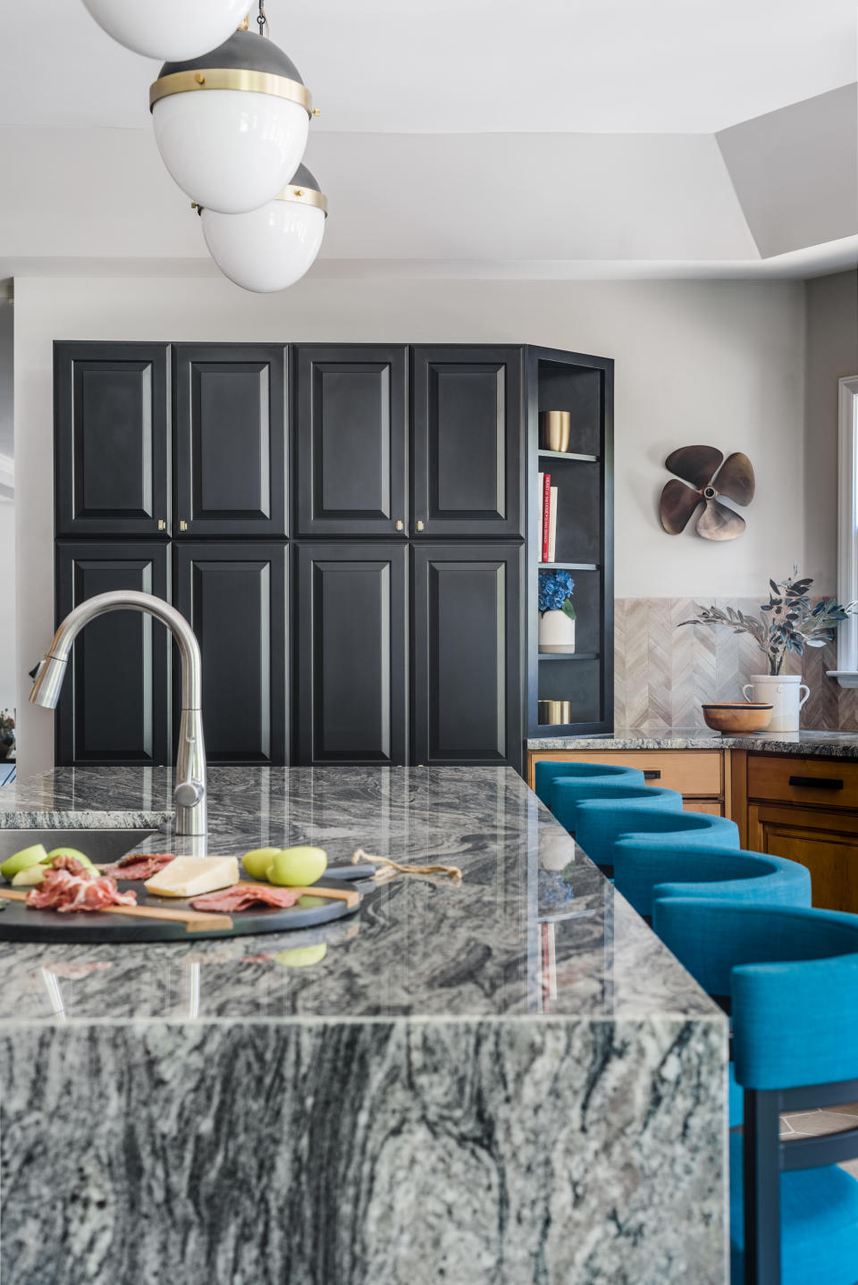 <p> When designing a kitchen, use a combination of colors, materials and finishes to create a characterful look – but just as you would in a living room, limit your palette to one main color and two accents. In this kitchen, interior designer Brenna Morgan used grey as the predominant shade in the marble-look island, with black painted cabinets as an accent next to warmer, stained wood cabinetry and bright turquoise bar stools in this lakeside retreat. </p>