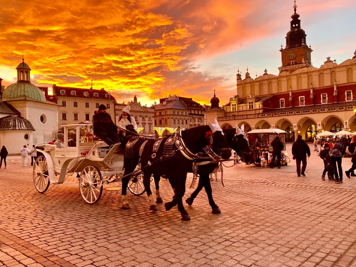 Golden hour: Winter visitors in the main square in Krakow, southern Poland (Charlotte Hindle)