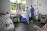 Medical staff attend to patients at the COVID-19 unit of the Marius Nasta National Pneumology Institute in Bucharest, Romania, Thursday, Sept. 23, 2021. Daily new coronavirus infections in Romania, a country of 19 million, have grown exponentially over the last month, while vaccine uptake has declined to worrying lows. Government data shows that 91.5% of COVID-19 deaths in Romania between Sept. 18-23 were people who had not been vaccinated. (AP Photo/Vadim Ghirda)