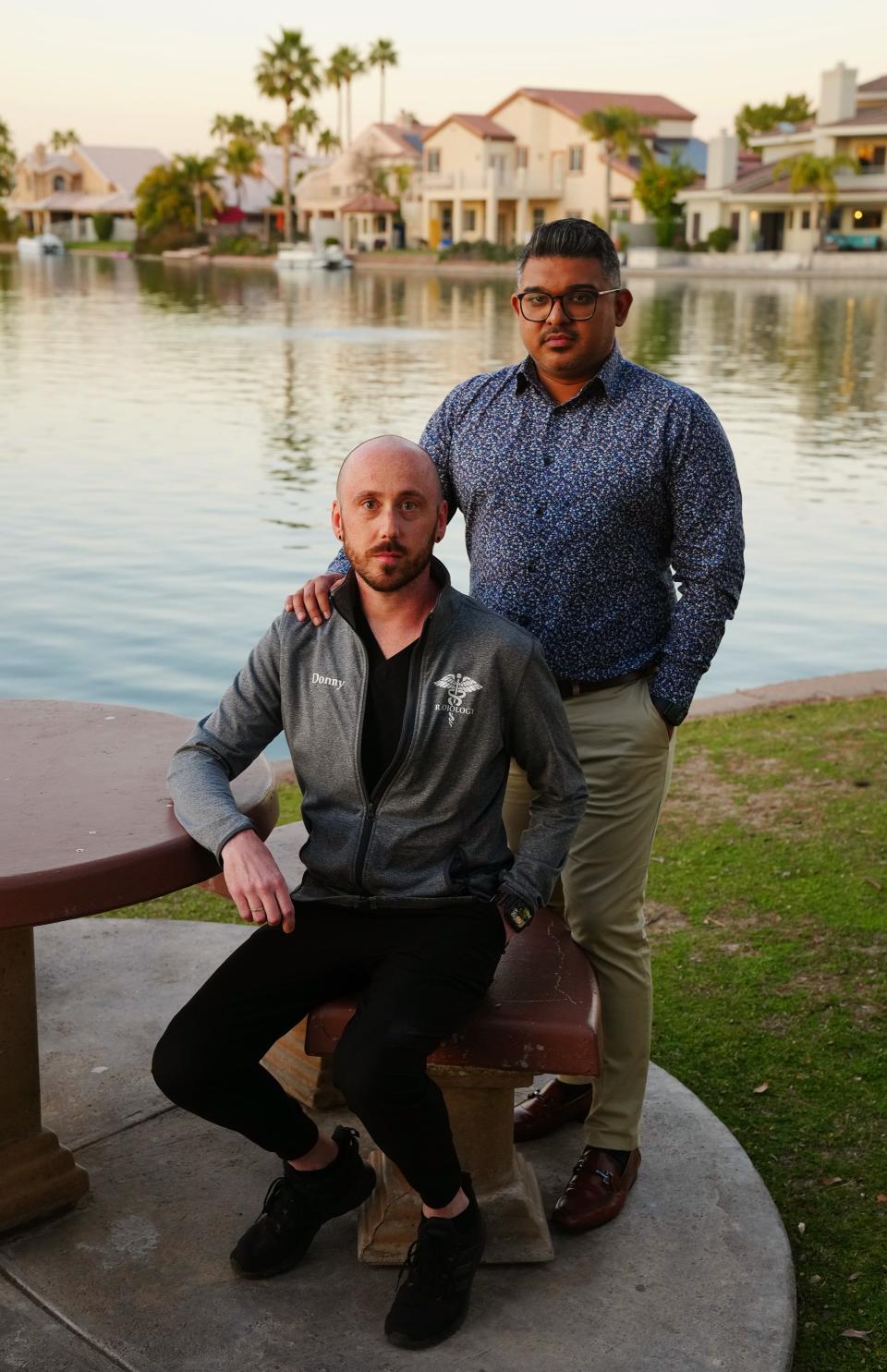 Don Williams (seated) and Jose Ortega pose for pictures at the lake outside of their apartment in Gilbert on Feb. 2, 2023.