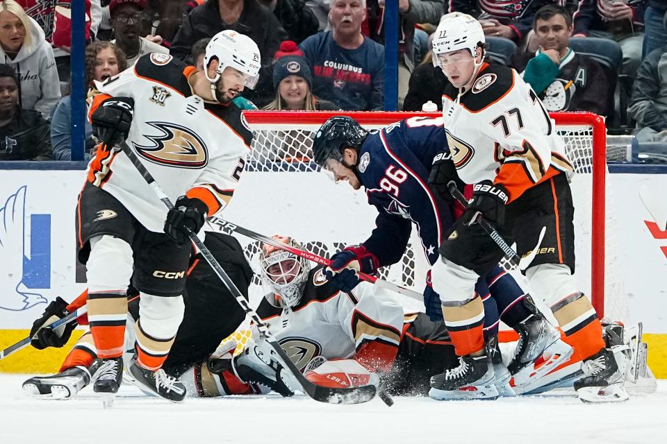 Oct 24, 2023; Columbus, Ohio, USA; Anaheim Ducks goaltender Lukas Dostal (1) saves the puck behind center Benoit-Olivier Groulx (24) with pressure from Columbus Blue Jackets center Jack Roslovic (96) during the second period of the NHL game at Nationwide Arena.