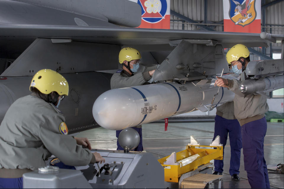 In this photo released by the Taiwan Presidential Office, ground crew attach a missile to the wing of an F-16 jet fighter at Air Force base during a visit by Taiwanese President Tsai Ing-wen, at a military base in Chiayi, southwestern Taiwan, Friday, Jan. 6, 2023. President Tsai visited a military base Friday to observe drills while rival China protested the passage of a U.S. Navy destroyer through the Taiwan Strait, as tensions between the sides showed no sign of abating in the new year. (Taiwan Presidential Office via AP)