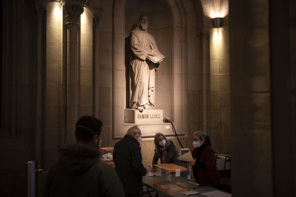 A man waits to cast his vote for the Catalan regional election at a polling station in the Barcelona University in Barcelona, Spain, Sunday, Feb. 14, 2021. Over five million voters are called to the polls on Sunday in Spain's northeast Catalonia for an election that will measure the impact of the coronavirus pandemic on the restive region's secessionist movement. (AP Photo/Felipe Dana)