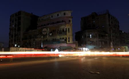 Vehicle lights cause light streaks on the road during a power outage in a residential area of Karachi, Pakistan, November 4, 2015. REUTERS/Akhtar Soomro/Files