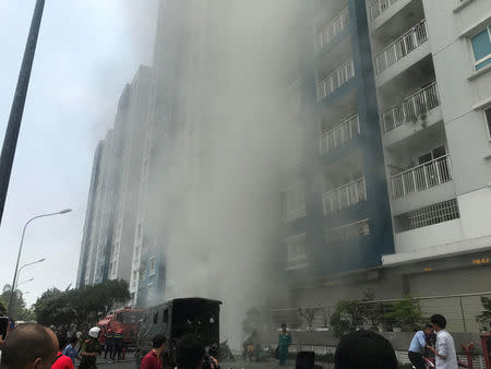 Firefighters extinguish a fire at an apartment block in Ho Chi Minh City, Vietnam March 23, 2018. VNA/Thanh Chung via REUTERS