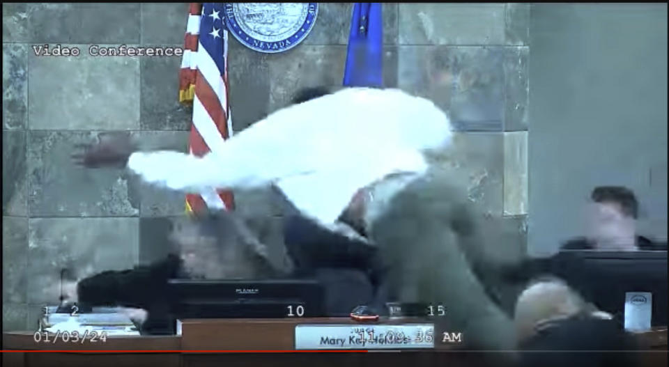 In this image from video provided by the Clark County District Court, a defendant identified by court officials and records as Deobra Redden is seen launching over the desk of Judge Mary Kay Holthus during his sentencing in a felony battery case on Wednesday, Jan. 3, 2024 in Las Vegas. Redden has now been indicted by a grand jury for attempted murder Thursday, Feb. 8.. (Clark County District Court via AP)