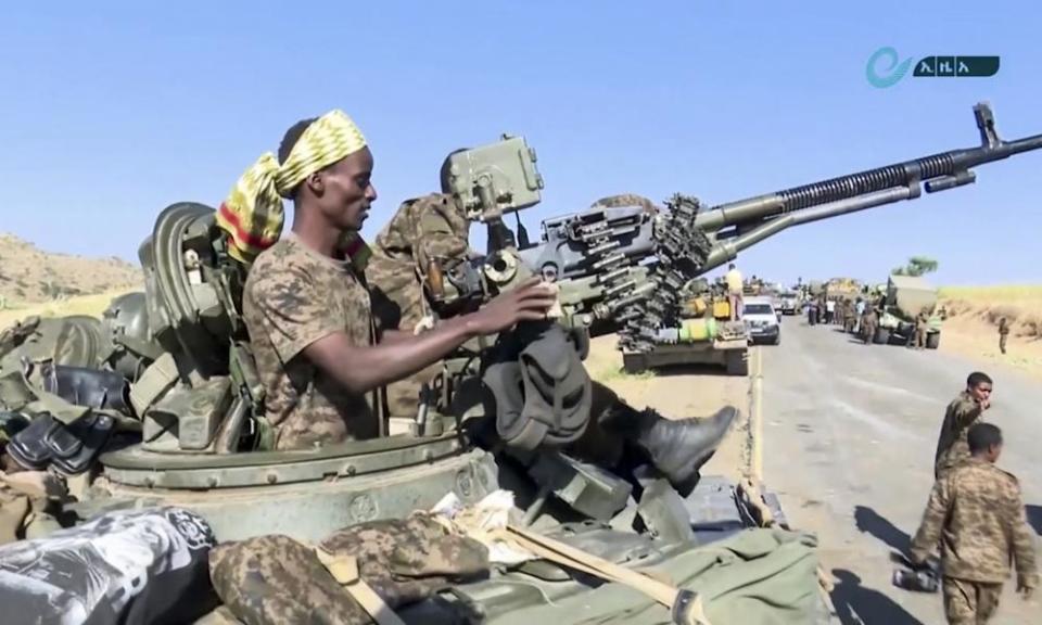 army personnel in tank aiming a large gun