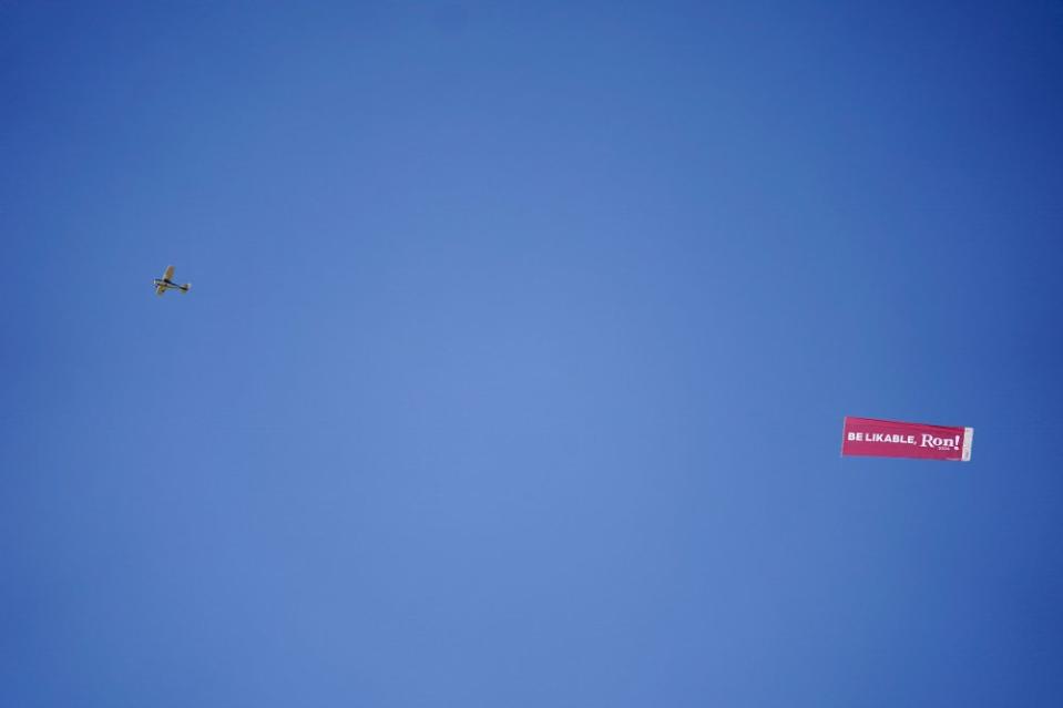 A plane flies over the Iowa State Fair pulling a banner with a message for DeSantis on, Aug. 12, 2023.<span class="copyright">Jeff Roberson—AP</span>