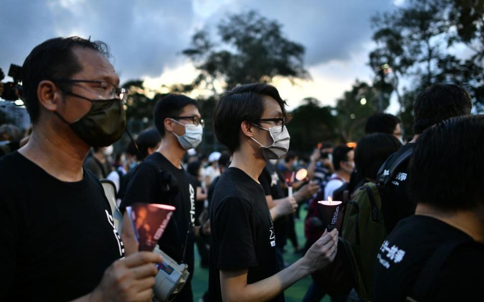 Activists hold a candle vigil to mark the Tiananmen Square protests of 1989, despite an official ban on proceedings - ANTHONY WALLACE/AFP