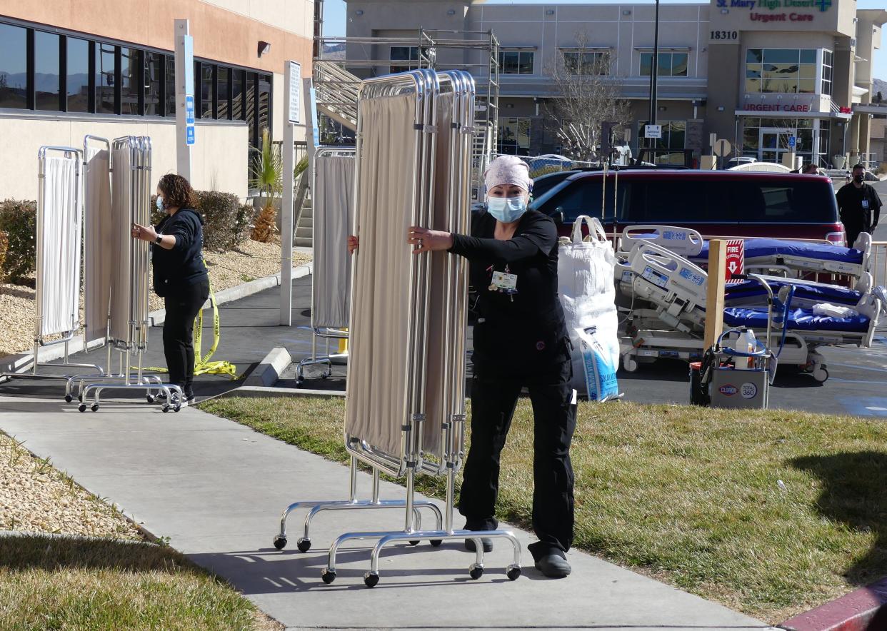 Nurses at Providence St. Mary Medical Center in Apple Valley transfer medical equipment and supplies from a medical tent back into the hospital.