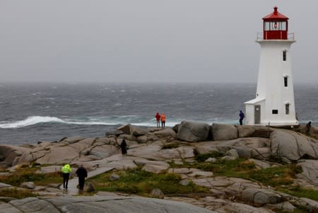 FILE PHOTO: Two RCMP officers visit Peggy's Cove Lighthouse during the arrival of Hurricane Dorian in Peggy's Cove