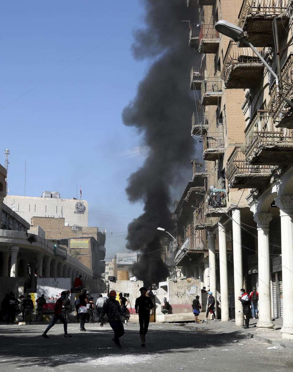 Anti-government protesters gather while security forces block al-Rashid Street during clashes in Baghdad, Iraq, Friday, Nov. 22, 2019. Iraq's massive anti-government protest movement erupted Oct. 1 and quickly escalated into calls to sweep aside Iraq's sectarian system. Protesters occupy several Baghdad squares and parts of three bridges in a standoff with security forces. (AP Photo/Hadi Mizban)