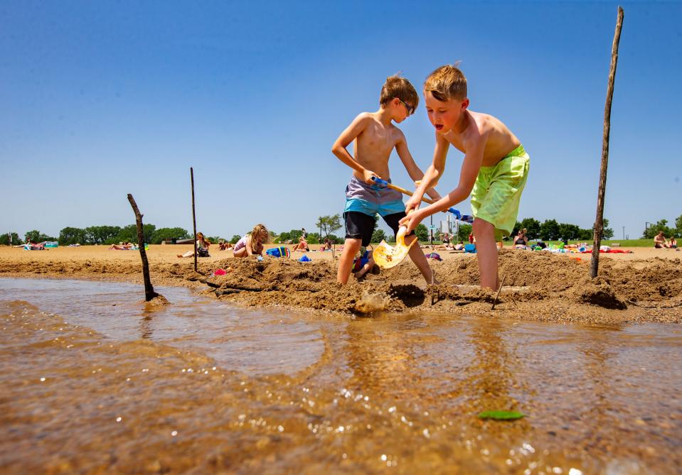 Korbin Daniels, left, and Jax Carper, both 8, dig in the beach of Blue Heron Lake at Raccoon River Park in West Des Moines on June 14, 2022. Forecasters predict another hot summer in Des Moines for 2024.