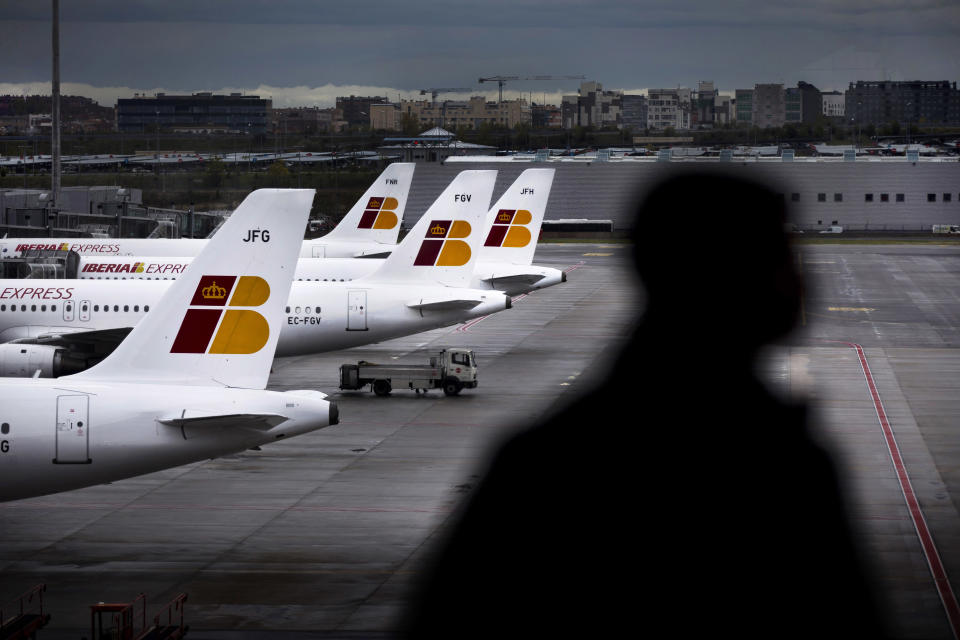 A man stands in front of a window watching Iberia jets in a parking zone at Barajas international airport in Madrid, Friday, Nov. 9, 2012. International Airlines Group on Friday warned that its Spanish carrier Iberia was "in a fight for survival" and unveiled a restructuring plan to cut 4,500 jobs as it reported a drop in third-quarter profit. (AP Photo/Daniel Ochoa de Olza)