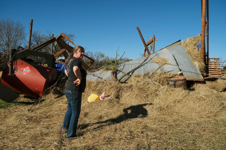 Teresa Elam on Monday surveys what was an eight-stall barn built by her parents and owned by her mother, Jean Hopkins, 83, who survived the storm in a closet.