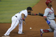 Miami Marlins first baseman Jesus Aguilar, left, is unable to catch the throw as Philadelphia Phillies' Jean Segura reaches first during the third inning of a baseball game, Monday, May 24, 2021, in Miami. (AP Photo/Wilfredo Lee)