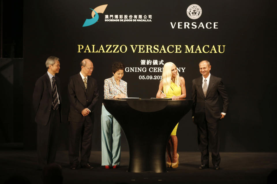 Angela Leong, Managing Director of SJM, third from left, and Donatella Versace, second from right, sign an agreement witnessed by Louis Ng, Director and Chief Operating Officer of SJM, left, Ambrose So, Chairman of the Board of Directors of SJM, second from left, and Gian Giacomo Ferraris, CEO of Versace, right, during the Palazzo Versace Macau signing ceremony in Macau Thursday, Sept. 5, 2013. Italian fashion house Versace and Macau casino company SJM said the Versace-themed hotel they're planning for the Asian gambling city will be tweaked to appeal to the local Chinese market and open in 2017. Versace and SJM Holdings signed a deal last month to build the hotel at SJM's Cotai resort in Macau. (AP Photo/Kin Cheung)
