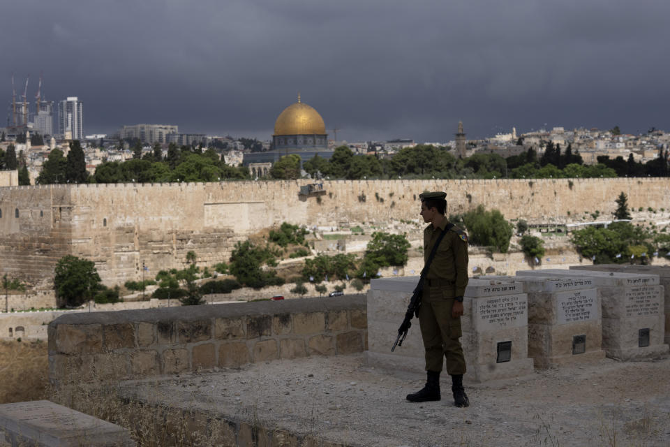 ARCHIVO - Un soldado israelí se detiene en el cementerio del Monte de los Olivos, a las afueras de la zona antigua de Jerusalén, mientras se vuelve hacia la Mezquita del Domo de la Roca en el complejo de la Mezquita de Al Aqsa, el lunes 13 de mayo de 2024. (AP Foto/Maya Alleruzzo, Archivo)