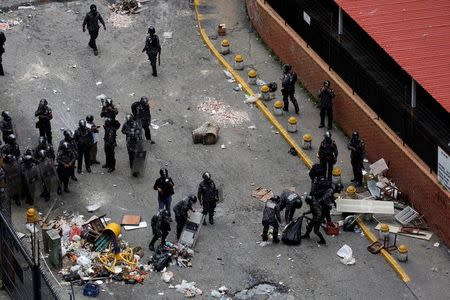 Riot police forces remove a barricade built by demonstrators on the street during a strike called to protest against Venezuelan President Nicolas Maduro's government in Caracas, Venezuela, July 20, 2017. REUTERS/Carlos Garcia Rawlins