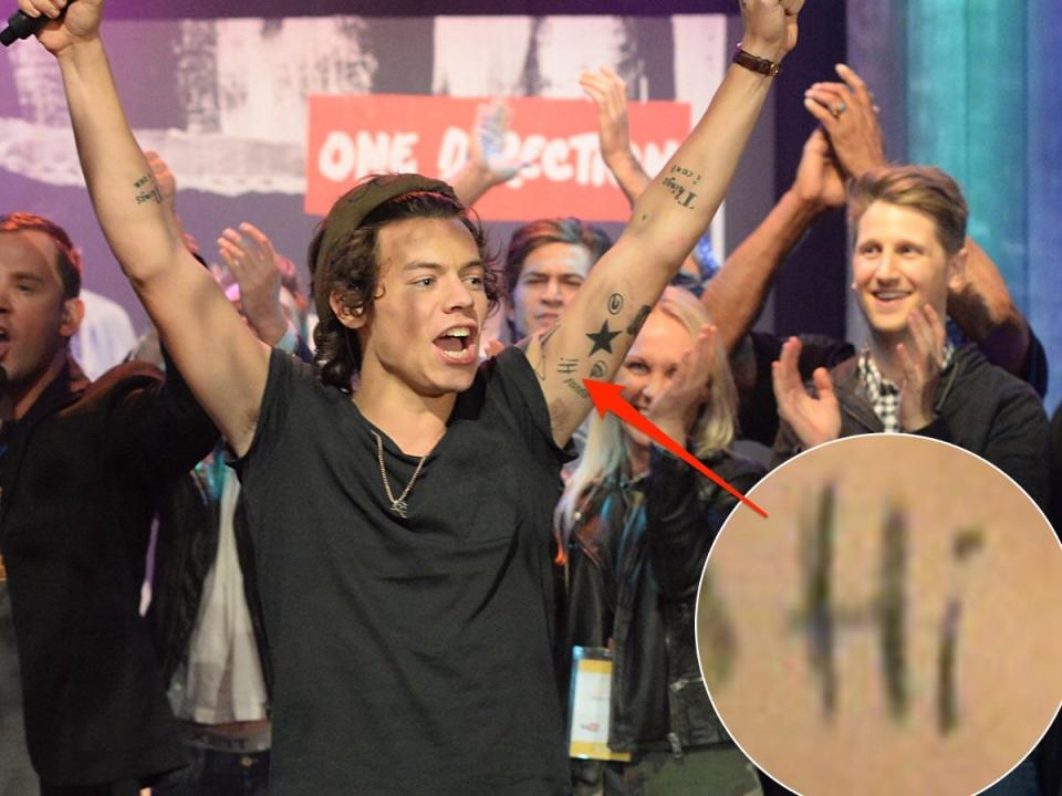 A red arrow pointing to Harry Styles' "Hi" tattoo on his left bicep.