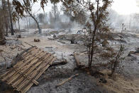 Smoke rises from smoldering houses in Kinma village, Pauk township, Magwe division, central Myanmar on Wednesday, June 16, 2021. Residents said people are missing after military troops burned the village the night before. (AP Photo)