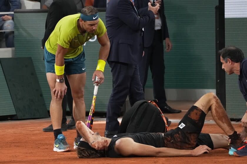 Rafael Nadal checks on Alexander Zverev after he fell to the court during their French Open semifinal June 3, 2022, in Paris.
