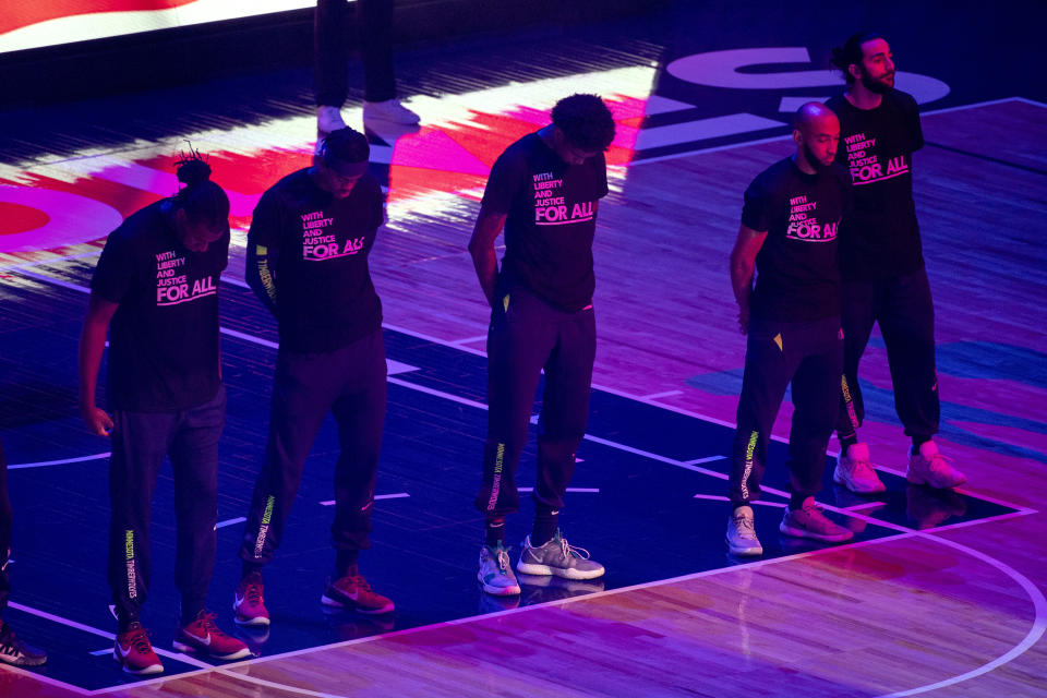 Jugadores de los Timberwolves de Minnesota guardan un minuto de silencio por Daunte Wright un ciudadano negro que murió baleado por la policía. La ceremonia se realizó el martes 13 de abril de 2021, antes del partido ante los Nets de Brooklyn (AP Foto/Craig Lassig)