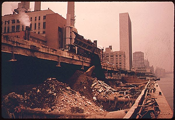 CONSTRUCTION RUBBLE IS LOADED ON BARGES IN THE EAST RIVER IN MANHATTAN, NEW YORK. IT WILL BE DUMPED AT A CONSTRUCTION DEBRIS DUMP SITE OFFSHORE IN THE NEW YORK BIGHT. SLUDGE IS DUMPED 12 MILES OFFSHORE, WASTE ACID 15 MILES AND CHEMICAL WASTES 106 MILES. DREDGE SPOILS AND DERELICT VESSELS ALSO ARE DISPOSED OF IN THE BIGHT