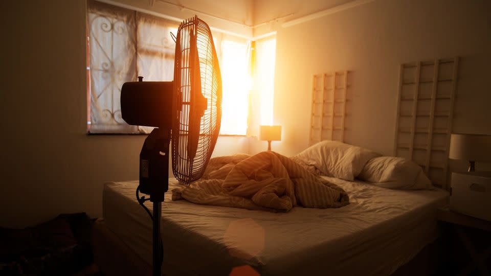 Fans, lukewarm showers, and watching what you eat and drink are a few of the many tips on how to sleep during a heat wave. - brazzo/iStockphoto/Getty Images