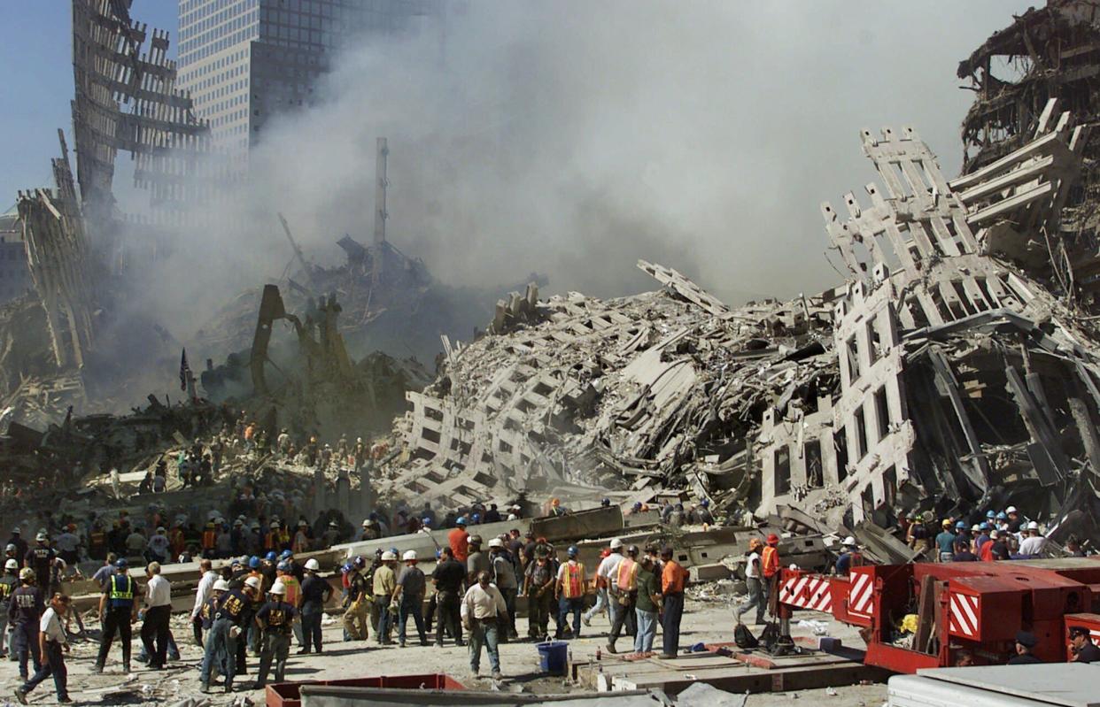 In this Thursday, Sept. 13, 2001 file photo, rescue workers continue their search as smoke rises from the rubble of the World Trade Center in New York. 
