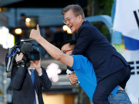 A supporter carries Moon Jae-in, presidential candidate of the Democratic Party of Korea, on his back during Moon's election campaign rally in Seoul, South Korea, May 6, 2017. REUTERS/Kim Kyung-Hoon