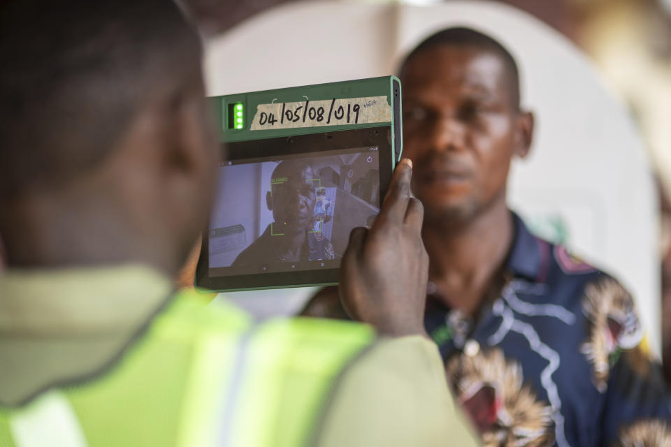 A man has his photo taken by an electoral worker before voting during the presidential elections in Agulu, Nigeria, Saturday, Feb. 25, 2023. Voters in Africa's most populous nation are heading to the polls Saturday to choose a new president, following the second and final term of incumbent Muhammadu Buhari. (AP Photo/Mosa'ab Elshamy)