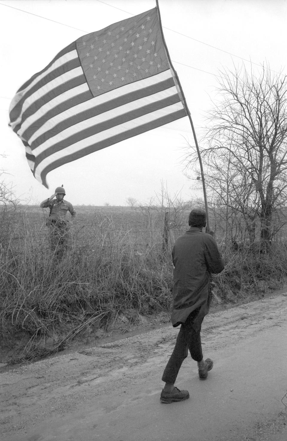 This March 23, 1965 photo provided by the Dan Budnik Estate shows a photograph taken by Dan Budnik of Will Henry 'Do-Right' being saluted by a sergeant of the Alabama National Guard during the Selma to Montgomery march in Alabama. Budnik an acclaimed photographer, noted for his portraits of artists in New York in the 1960s along with the civil rights movement and Native American culture, has died in Arizona at age 87. Budnik's nephew Kim Newton says his uncle died last Friday, Aug. 14, 2020, of natural causes at an assisted living facility in Tucson. (Dan Budnik/Dan Budnik Estate via AP)