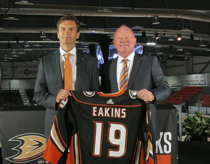 FILE - In this Monday, June 17, 2019 file photo, Anaheim Ducks head coach Dallas Eakins, left, and general manager Bob Murray pose with a jersey at Great Park Ice in Irvine, Calif. General manager Bob Murray saw intermittent signs of progress from his young Ducks players and first-year coach Dallas Eakins while Anaheim missed the playoffs for the second consecutive season. (AP Photo/Greg Beacham, File)