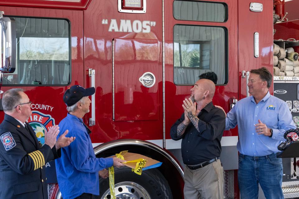 Left to right: Lake County Fire Chief Jim Dickerson, Bobby Liles, Jerry Roach and Lake County Commissioner Kirby Smith unveil the dedication to Amos Roach on the side of Station 21's new fire engine on Monday.