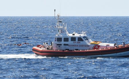 Migrants jump off the Spanish rescue ship Open Arms, close to the Italian shore in Lampedusa