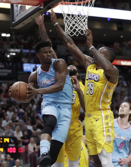 Miami's Jimmy Butler looks to pass after driving against Lakers defenders Dwight Howard (39) and Anthony Davis.