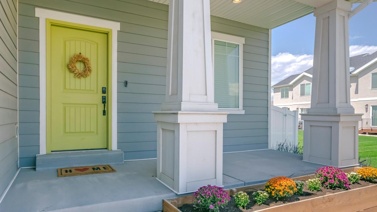 Home with porch and flowers in the garden.