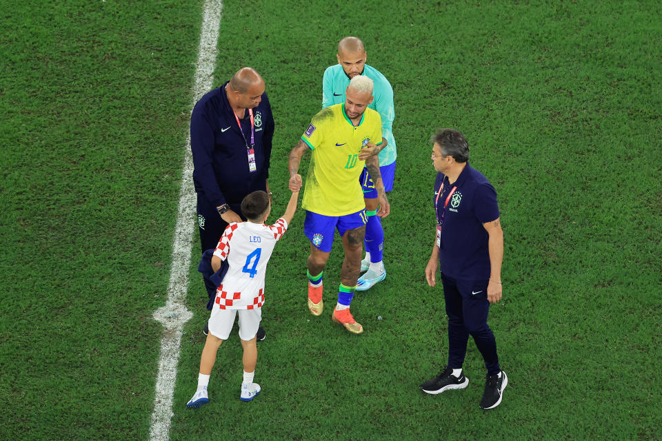 AL RAYYAN, QATAR - DECEMBER 09: Neymar and Dani Alves of Brazil look dejected as they embrace a fan after their sides' elimination from the tournament after a penalty shoot out loss during the FIFA World Cup Qatar 2022 quarter final match between Croatia and Brazil at Education City Stadium on December 09, 2022 in Al Rayyan, Qatar. (Photo by Buda Mendes/Getty Images)