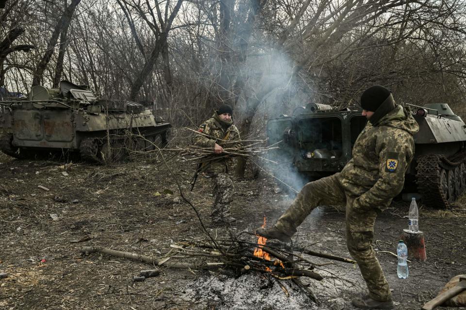 Ukrainian servicemen light a fire to warm themselves up in the region of Donbas, on March 5, 2023.