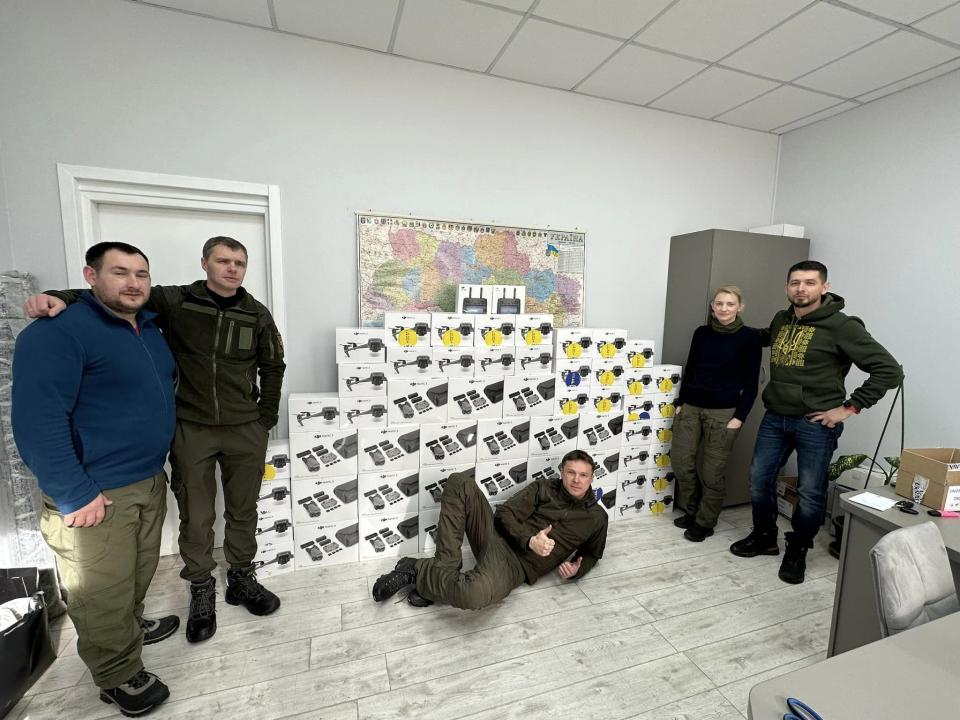 Roman Panasiuk (right), director of IC Construction, Hennadiy Vaskiv (center), head of All For Victory charity, and Johanna-Maria Lehtme, head of Glory To Ukraine charity (second from right), pose for a photograph with the equipment bought for Ukraine's military with Estonian people's donations on Feb. 14, 2023. (Hennadiy Vaskiv via Facebook)