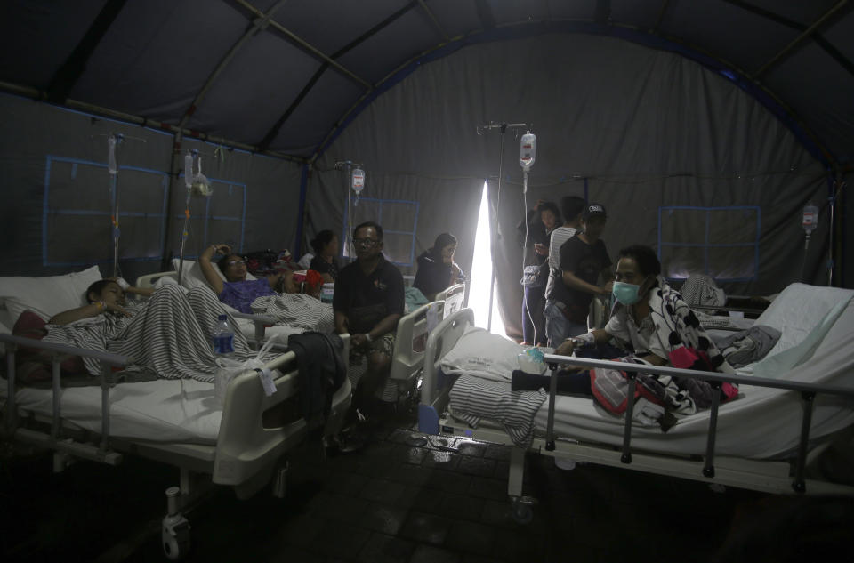 Patients are evacuated to a tent outside a hospital, following an earthquake in Bali, Indonesia, Monday, Aug. 6, 2018. A powerful earthquake struck the Indonesian tourist island of Lombok on Sunday, shaking neighboring Bali, one week after another quake on Lombok killed more than a dozen. (AP Photo/Firdia Lisnawati)